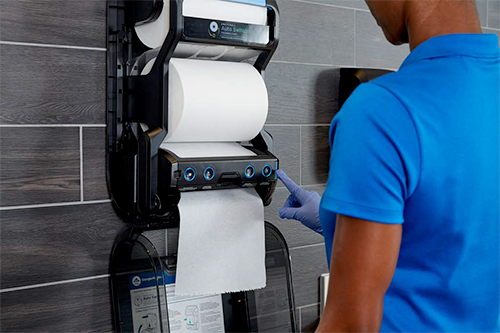 Employee replenishing a Georgia Pacific paper towel dispenser